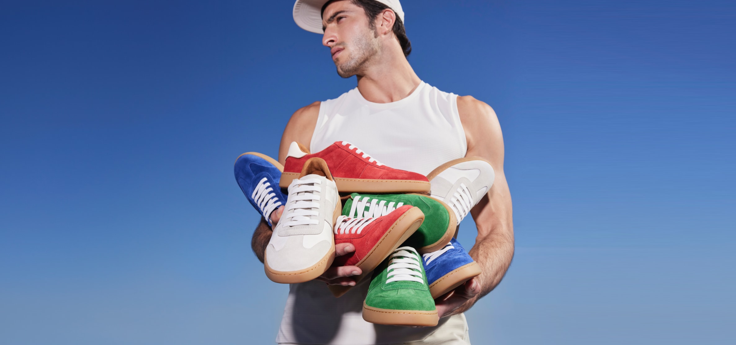 man holding several sneakers in multiple colors