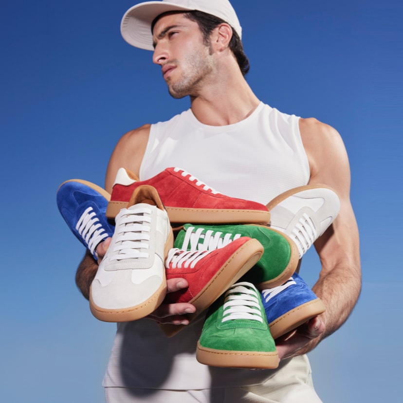 man holding several sneakers in multiple colors