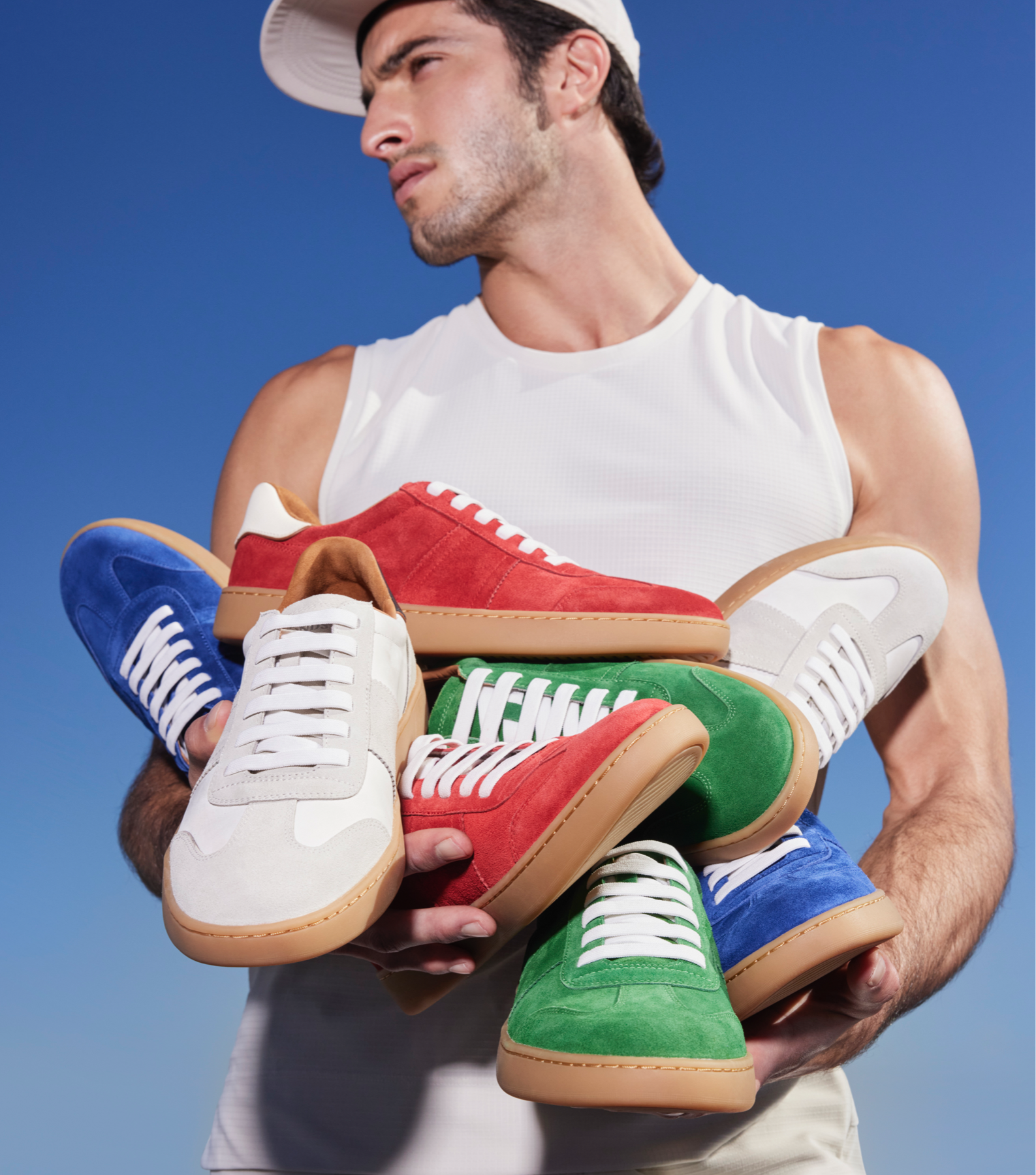 man holding ludlow sneakers in many colors