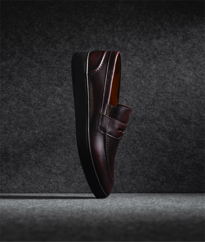 One single Allen Edmonds Randolph 2.0 Penny Loafer in burgundy leather, displayed vertically on its toe. 