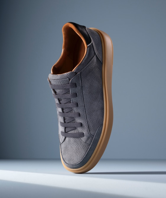 Men’s gray textured leather sneaker with tan rubber sole and brown leather lining
