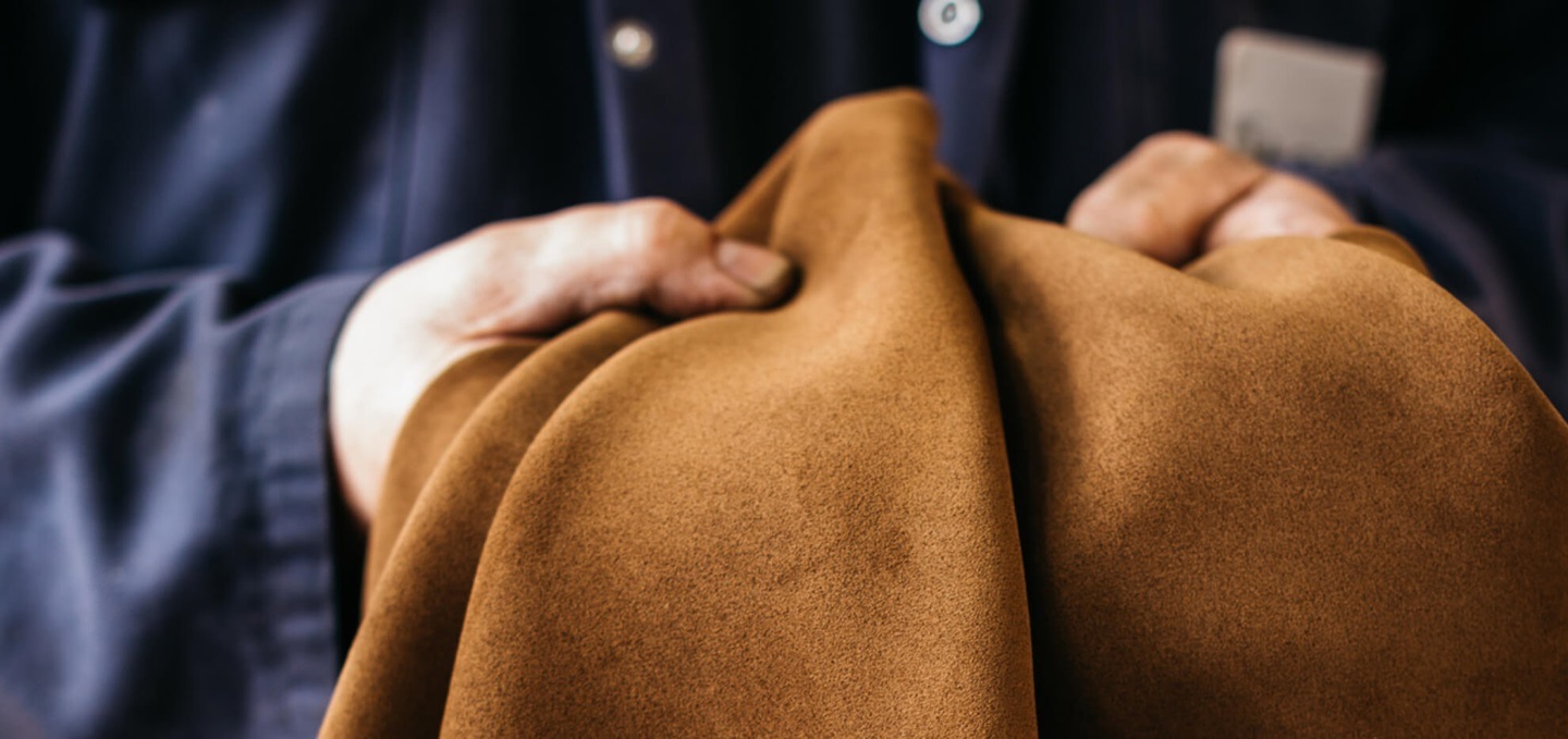 hands holding large piece of leather