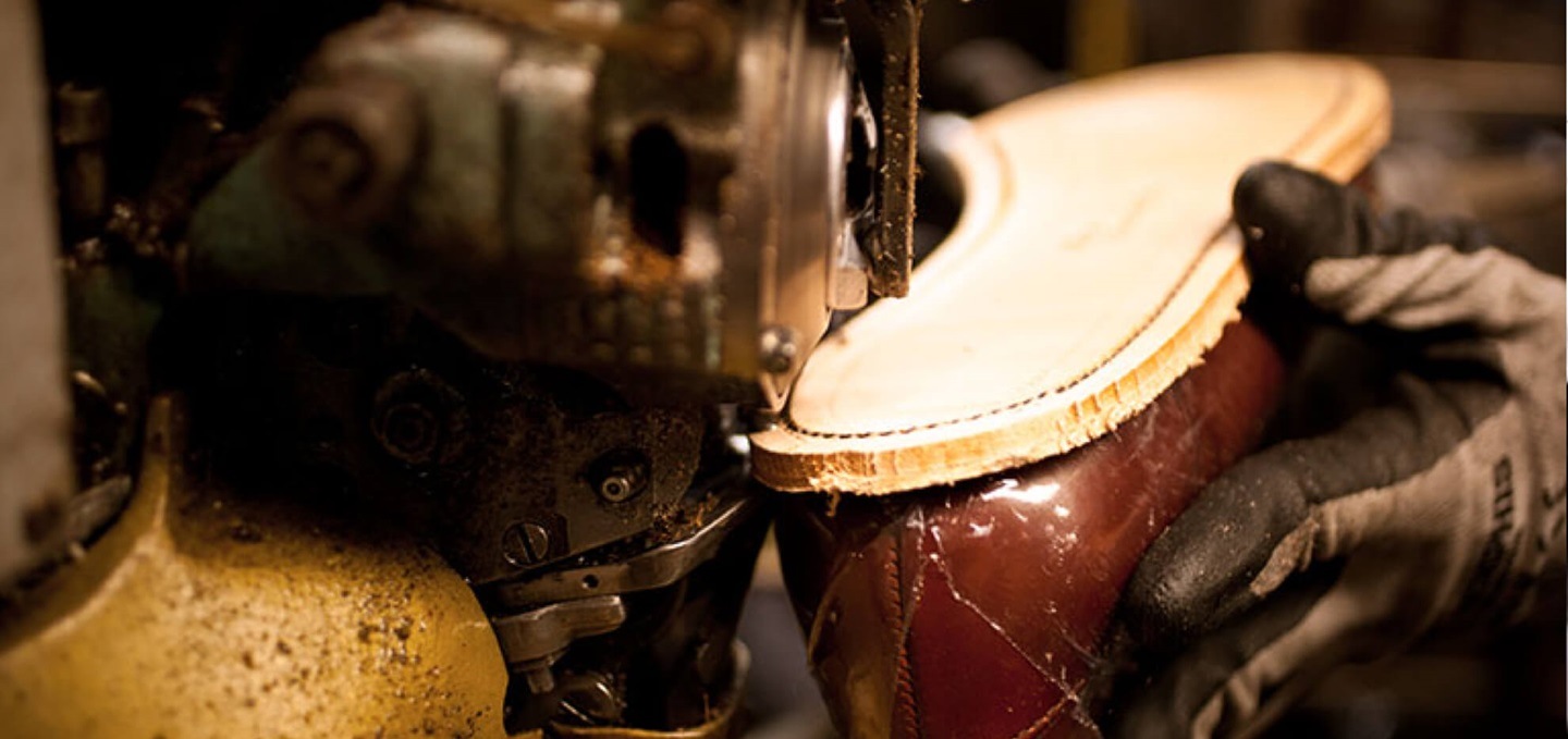 craftsperson adding sole to an Allen Edmonds shoe